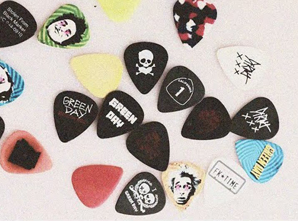 Collection of Green Day guitar picks on white background
